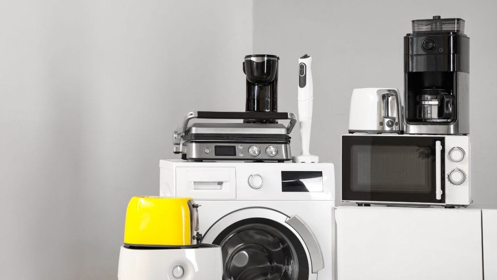 A variety of kitchen appliances displayed on a table, including a blender, toaster, and coffee maker.